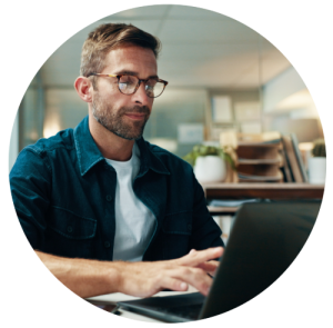 A man looking down at his laptop, typing.